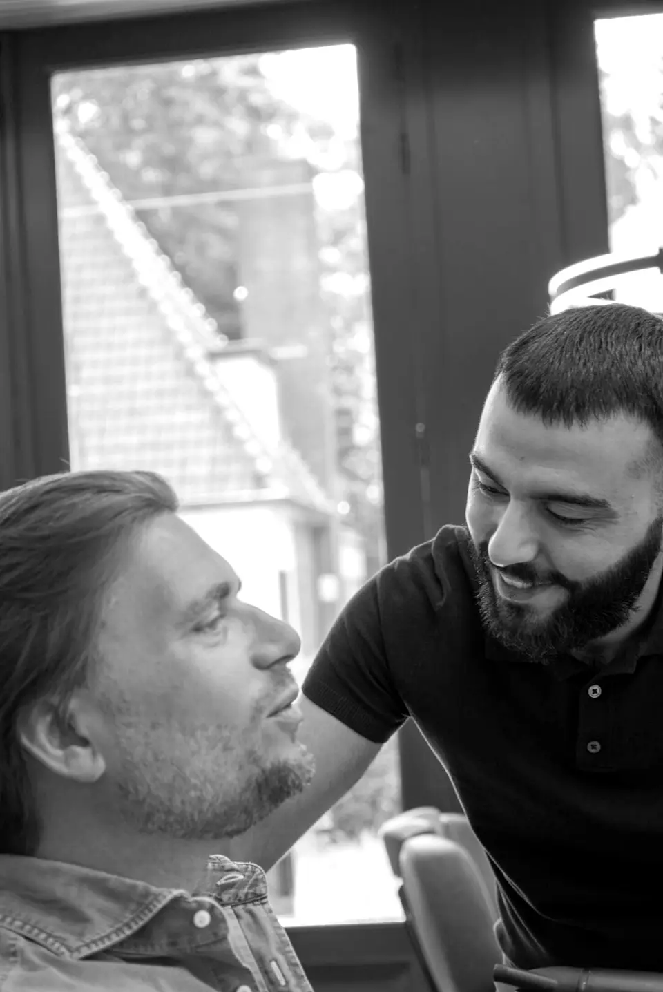 Kadir bespreekt de baard met een klant in de stoel
