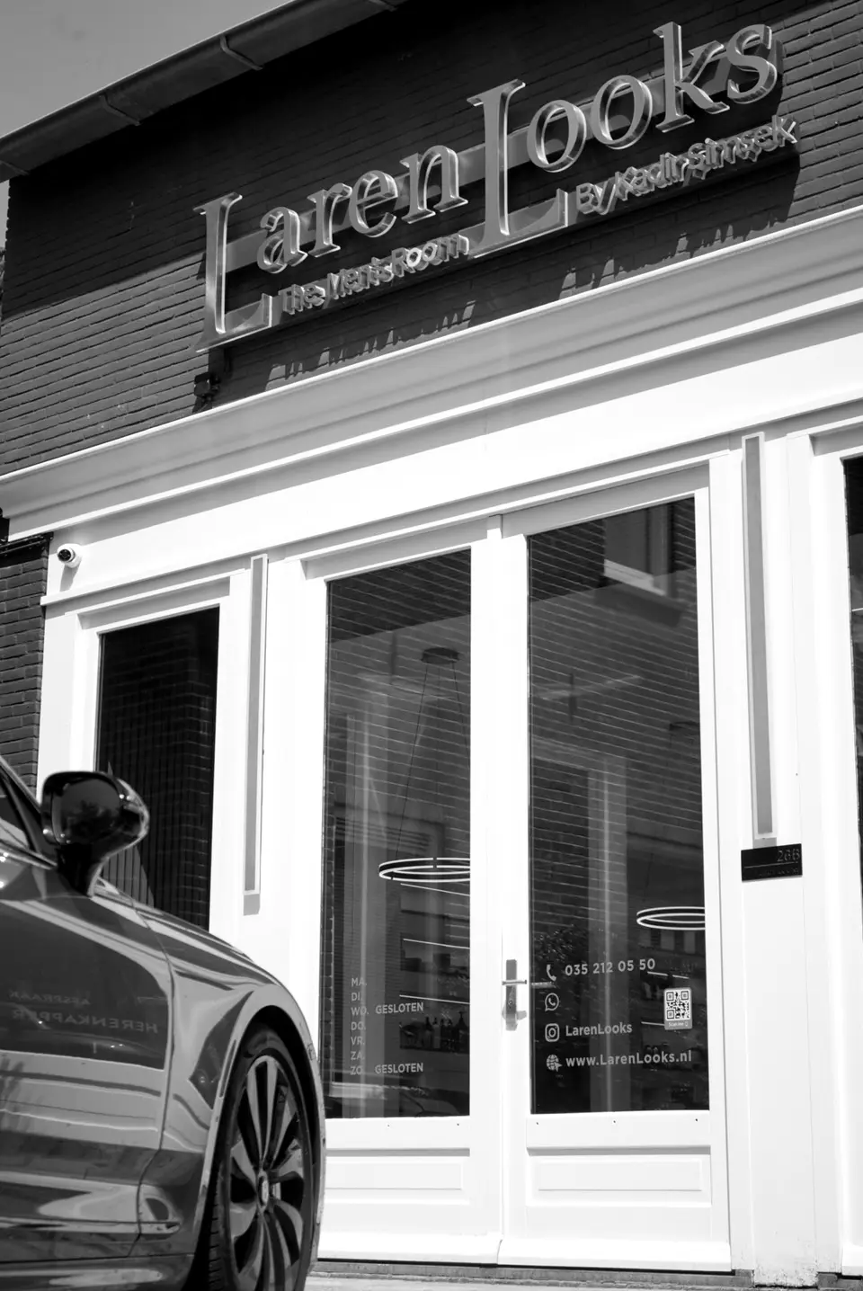 Gevel van Laren Looks aan de Nieuweweg met een auto voor de deur