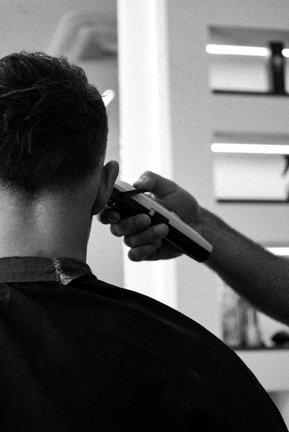 Tondeuse langs het oor bij een korte herencoupe